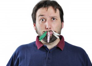 Man with his mouth closed shut by close pins